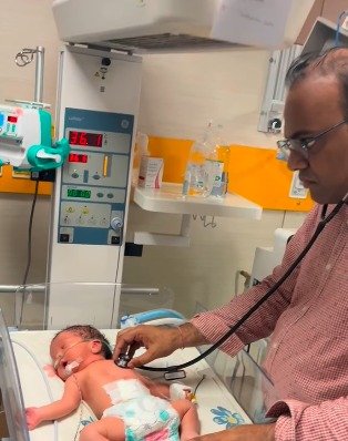 Dr. Saini examining a newborn